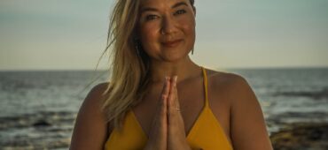 peaceful woman doing yoga with folded hands on beach