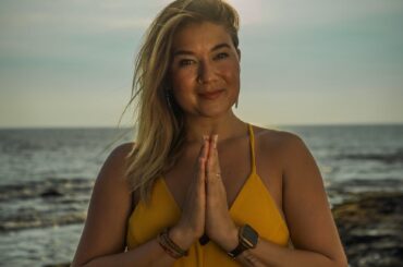 peaceful woman doing yoga with folded hands on beach